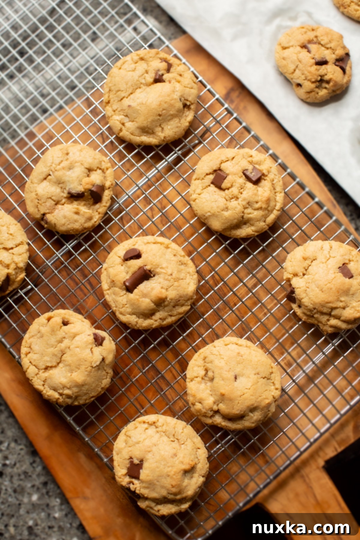 coconut chocolate chip cookies on a cooling rack and wooden cutting board 