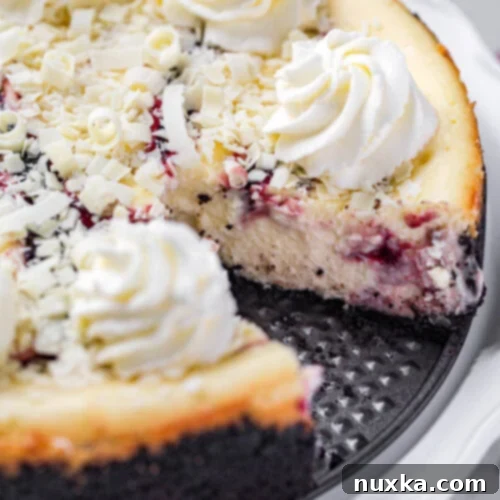 White Chocolate Raspberry Ripple Cheesecake 2 White Chocolate Raspberry Swirl Cheesecake with white chocolate shavings and whipped cream