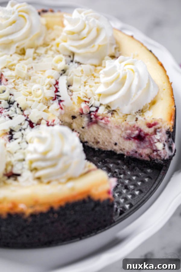 White chocolate raspberry swirl cheesecake (copycat cheesecake factory white chocolate raspberry truffle cheesecake topped with white chocolate shavings and whipped cream topping)