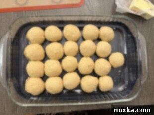sourdough dinner rolls dough in a dish getting ready to rise
