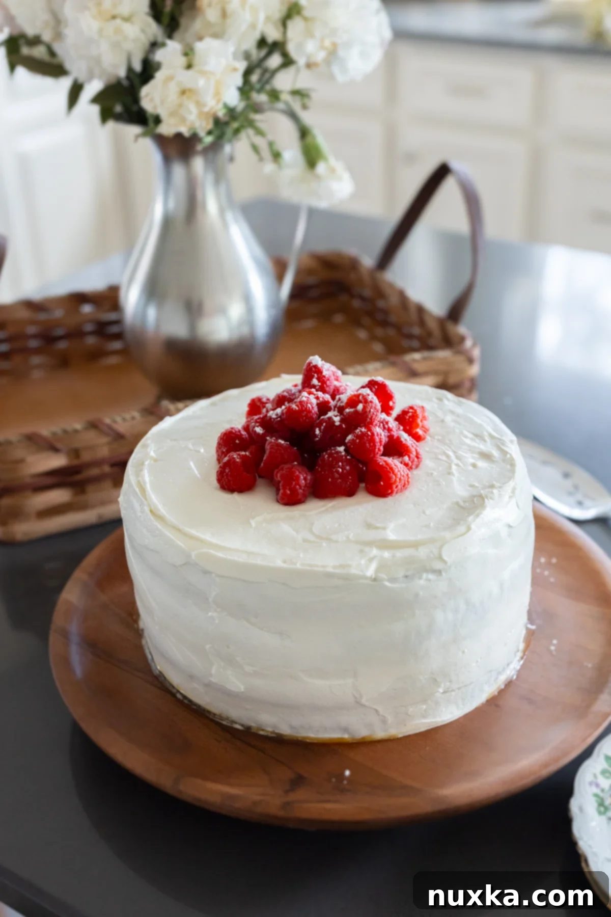 whole wheat raspberry honey cake on a wooden cake stand