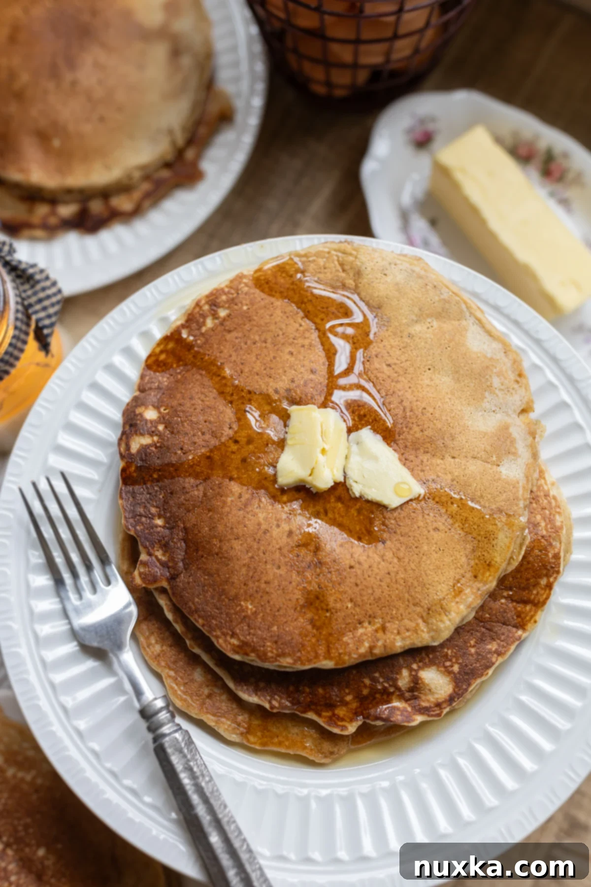 whole wheat sourdough pancakes served on a plate with butter and maple syrup
