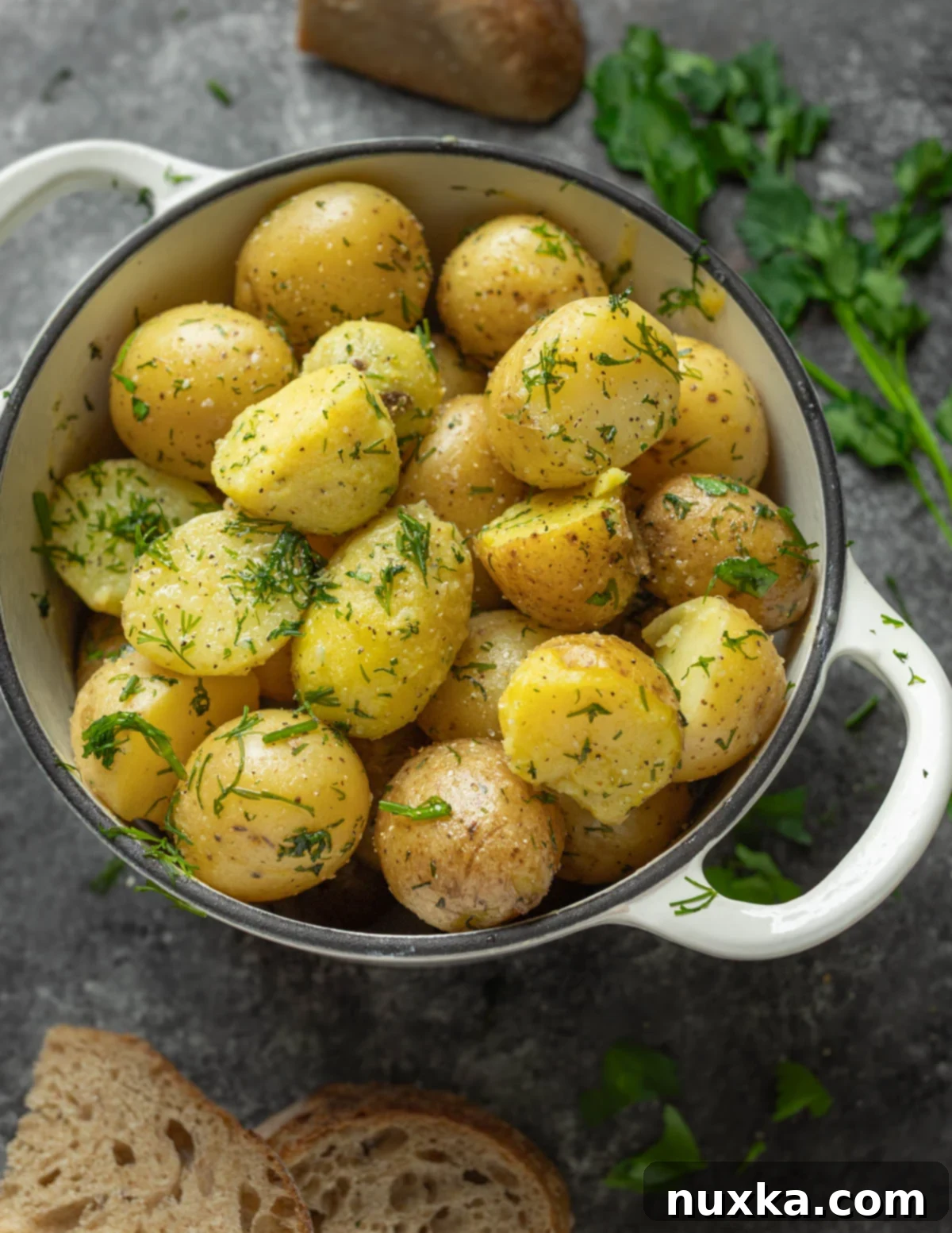 boiled potatoes in a dutch oven pot tossed in garlic salt, butter, and dill