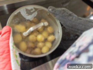 coating the boiled and steamed potatoes in melted butter and seasonings