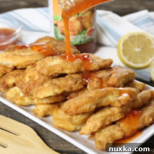 Crispy Chinese Chicken Fingers 13 Close-up of crispy Asian chicken fingers with sweet chili drizzle.