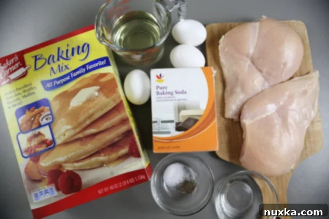 Raw chicken breasts and ingredients laid out for making Chinese chicken fingers.