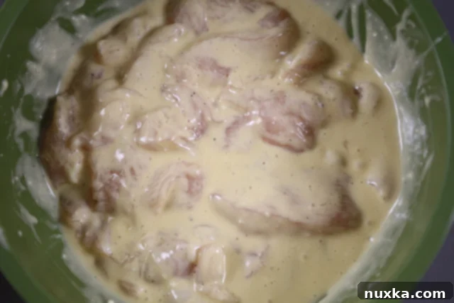 Chicken strips fully coated in batter, ready to be fried.