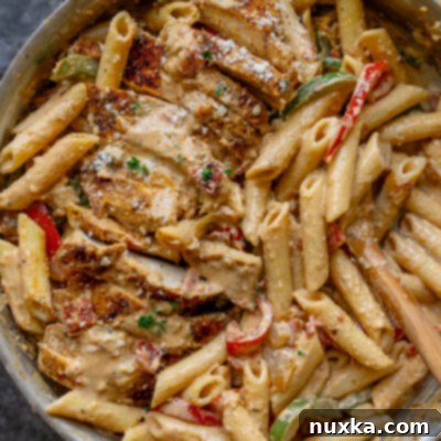 Spicy Creamy Cajun Chicken Pasta 4 creamy cajun chicken pasta in a skillet with bell peppers and onion