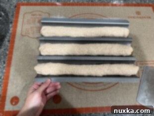 three sourdough baguettes on a baguette pan ready to be put into the fridge over night