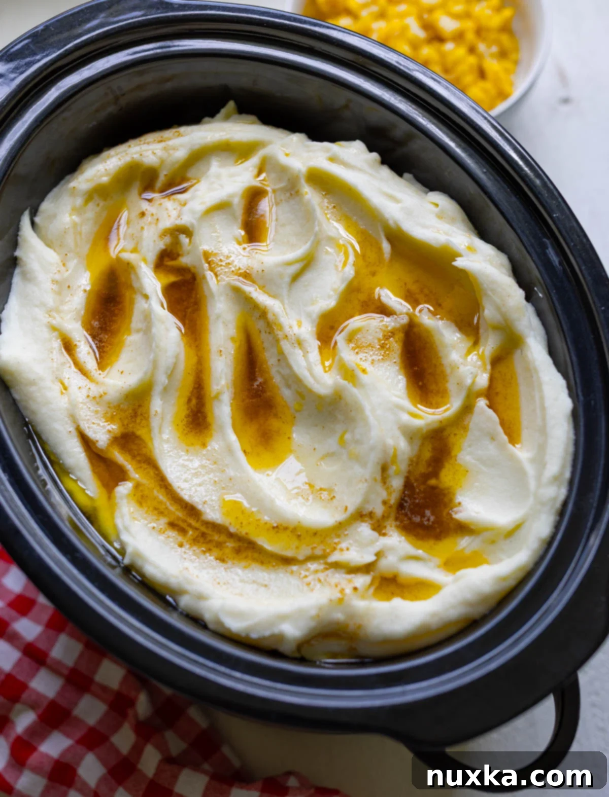 Close-up of creamy brown butter mashed potatoes in a serving bowl, garnished with fresh herbs.