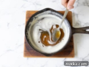 Brown butter simmering in a small saucepan, showing the golden-brown flecks.