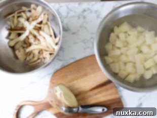 Peeled and diced Russet potatoes soaking in cold water to prevent oxidation.