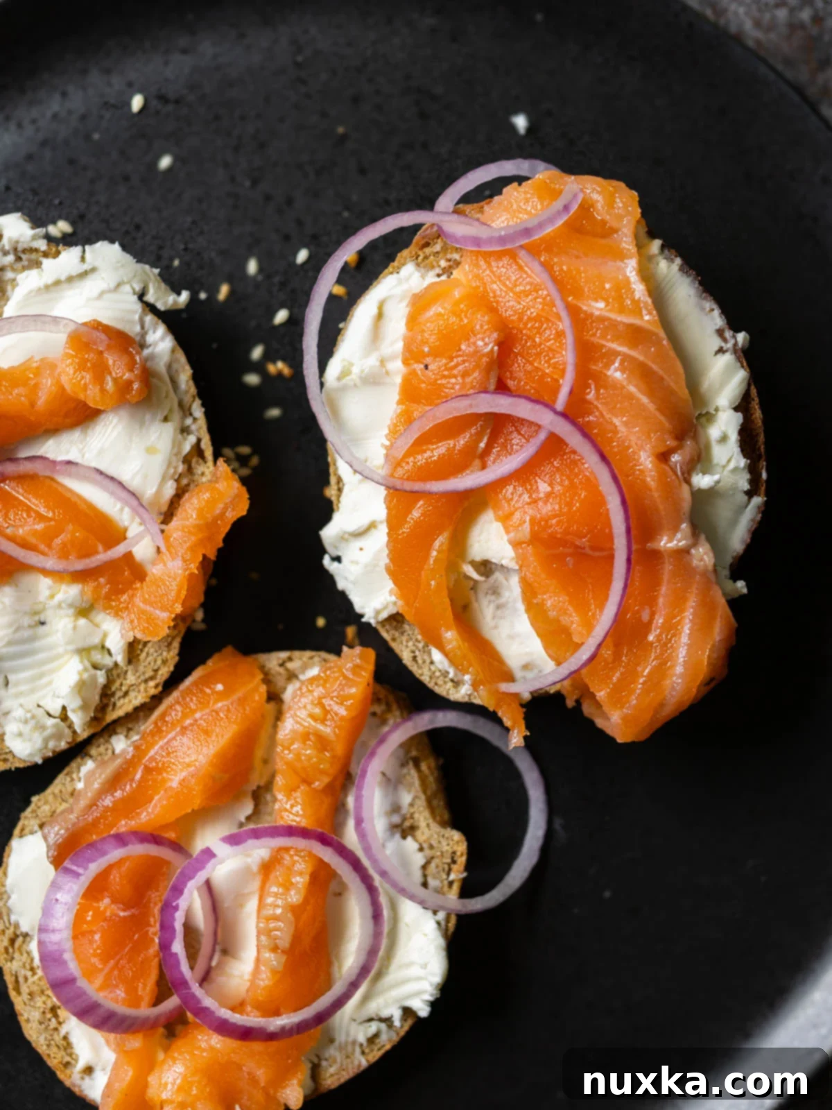 lox bagel with homemade gravlax topped with cream cheese and purple onions