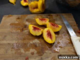 hands peeling and slicing fresh peaches for canning