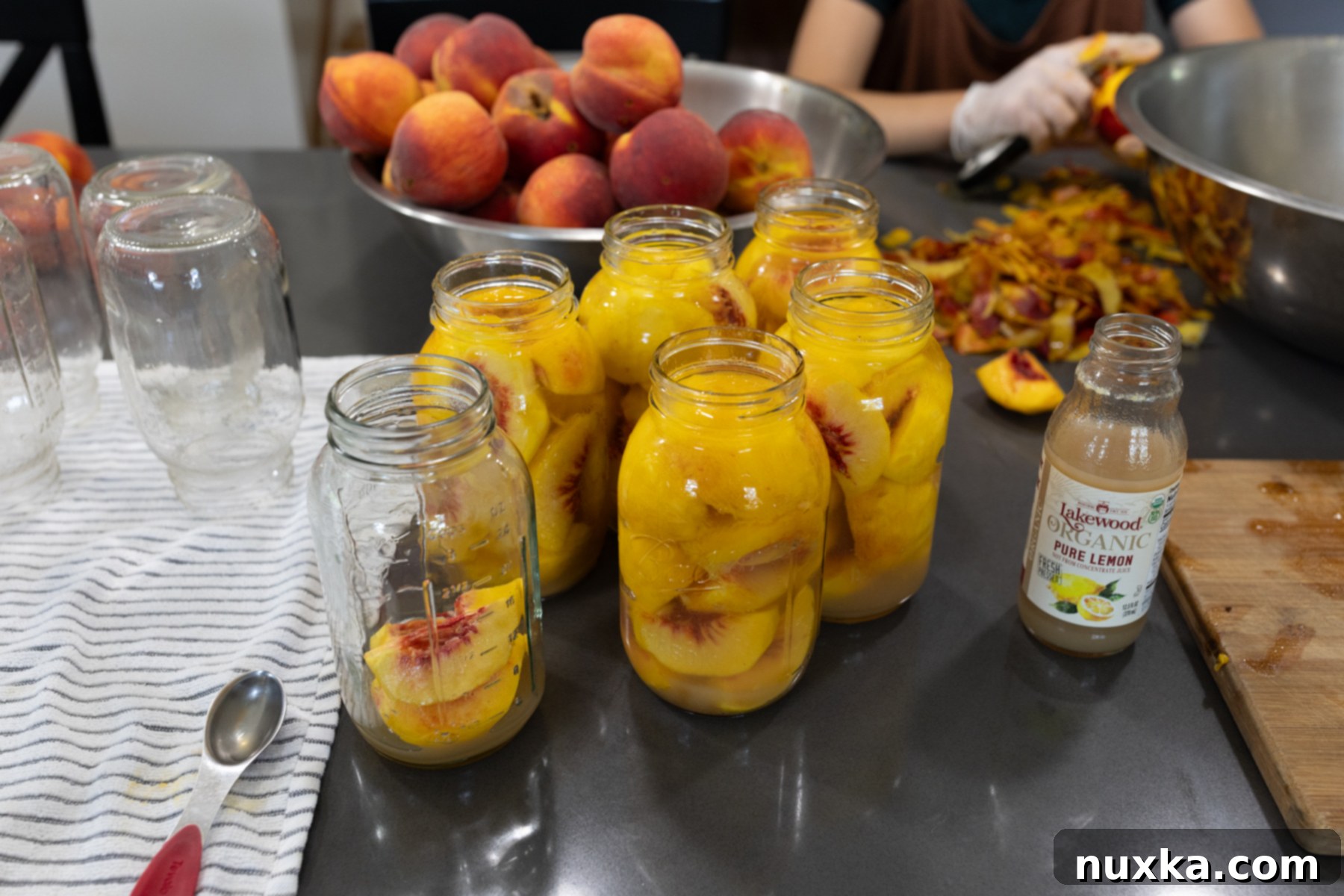 jars of peaches being processed in a water bath canner at home