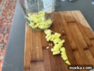Fresh banana peppers sliced into rings on a cutting board, ready for pickling.