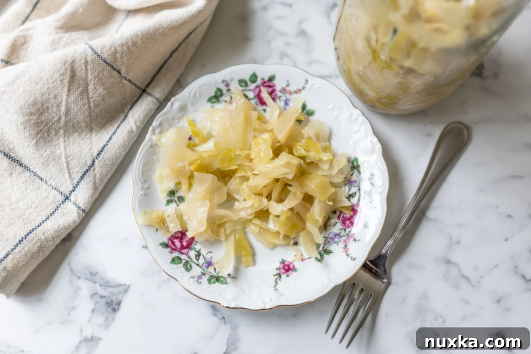 Homemade crunchy sauerkraut served on a white plate with fresh dill garnish