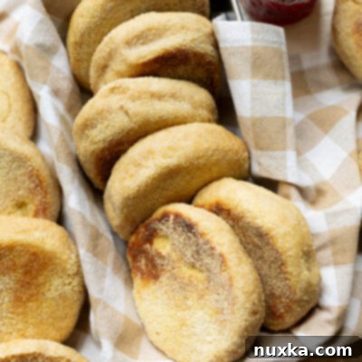 Wholesome Whole Wheat English Muffins 12 Whole Wheat English muffins arranged on a farmhouse kitchen towel in a bread pan