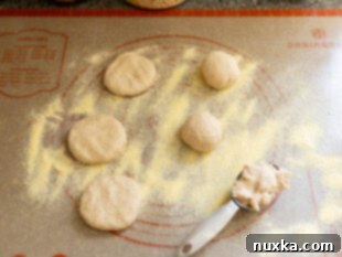 Shaping whole wheat English muffin dough with cornmeal on a work surface