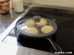 Cooking whole wheat English muffins on a cast iron skillet with a lid