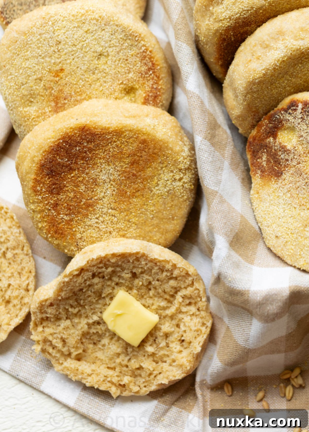 Close-up shot of a perfectly split Whole Wheat English Muffin, revealing abundant nooks and crannies, ready for butter and jam