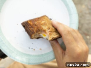 image of hot mountain pie sandwich on a paper plate outdoors (camping)