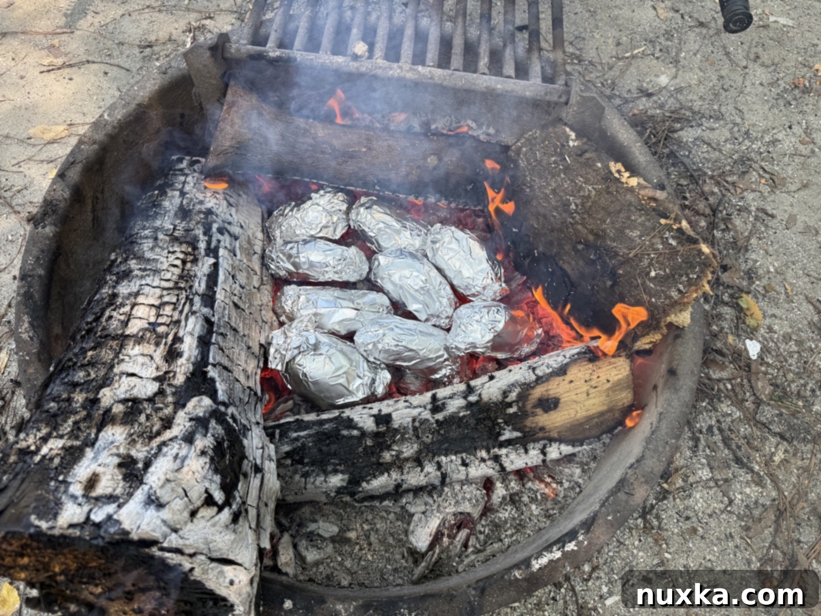 image of baked potatoes on embers wrapped in foil