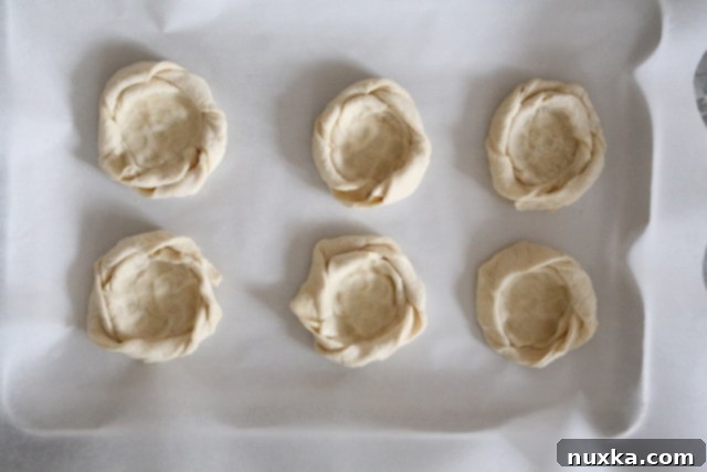 Indented puff pastry nests, showing the depressions ready for the cream cheese filling