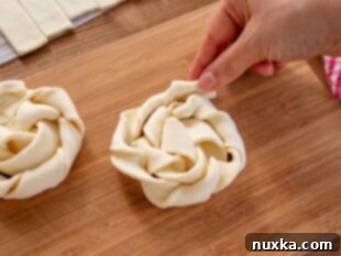 Twisted rounds of puff pastry dough forming the base of a danish