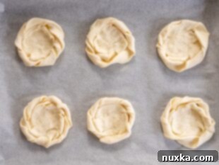 Prepared puff pastry dough shaped into nests, ready for filling with cream cheese
