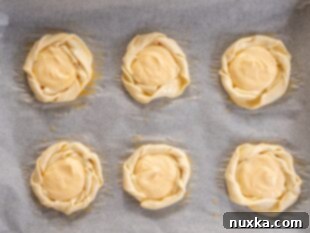 Cheese danish pastries being filled with cream cheese mixture