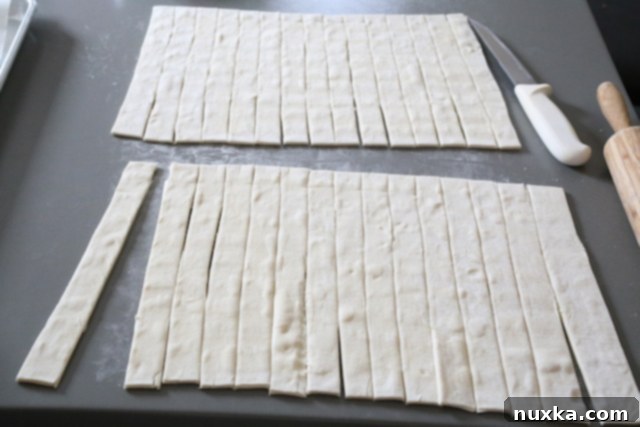 Preparing puff pastry strips for cheese Danish, showing sheets cut into narrow strips