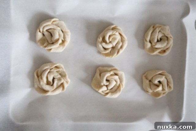 Puff pastry nests created by twisting strips of puff pastry to form rounds on a baking sheet