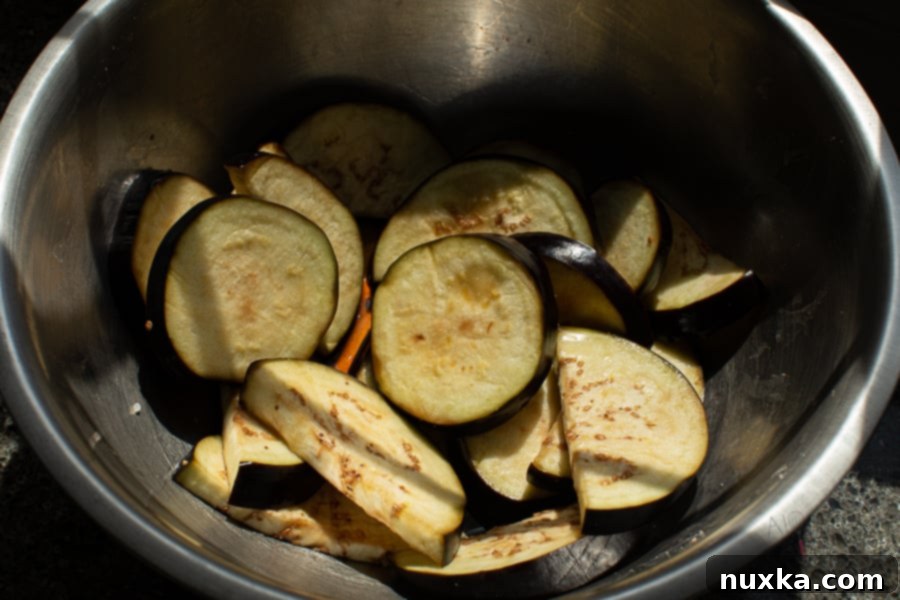 Salting eggplant slices before cooking to remove bitterness and soften texture