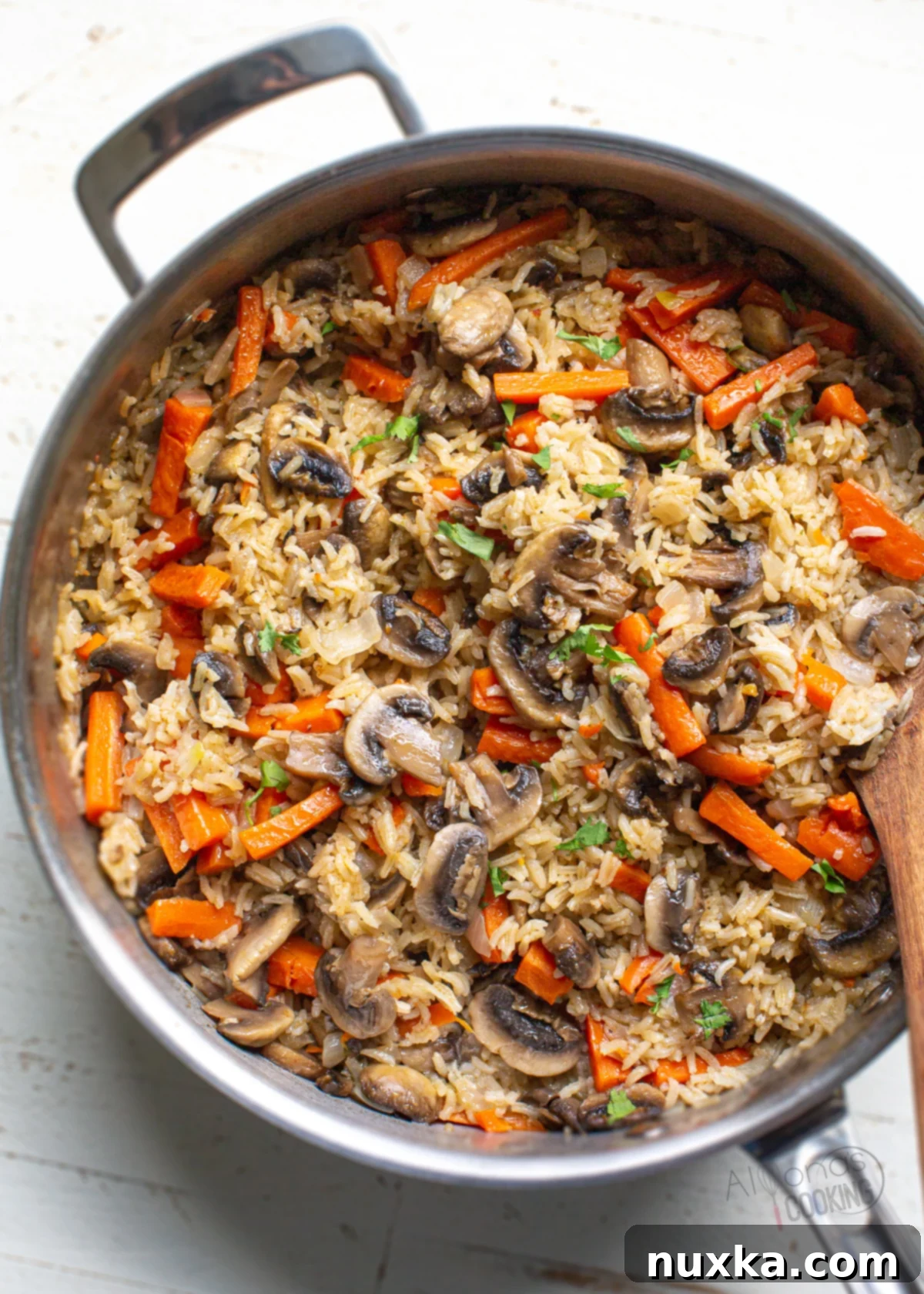 Mushroom rice pilaf in a pan, steaming hot and ready to serve.