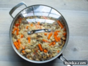 Steamed and cooked mushroom rice pilaf in a pan, ready for fluffing.