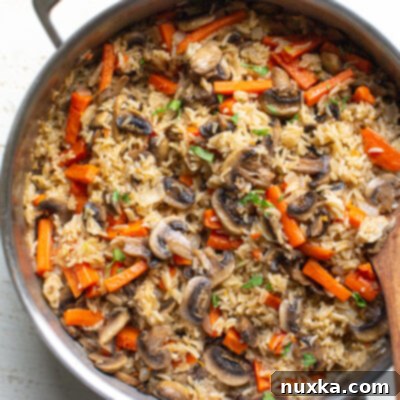 Close-up of mushroom rice pilaf in a pan, garnished and ready to serve.