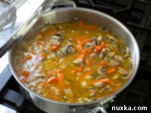 Water added to the mushroom rice mixture in a pan, brought to a boil.
