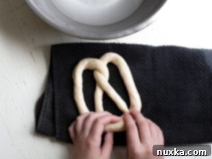 Shaping pretzel dough into a U-shape and twisting