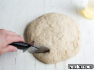 Cutting pretzel dough with a pizza cutter into strips