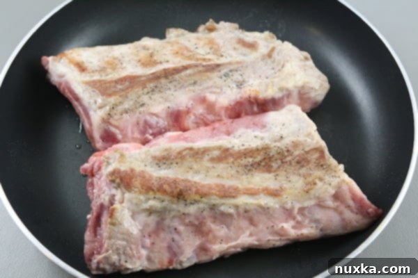 Searing ribs in a pan before slow cooking