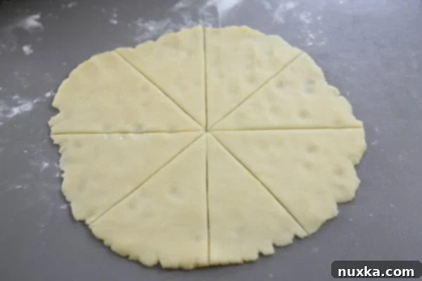 Rolling a Nutella-filled dough slice into a crescent shape