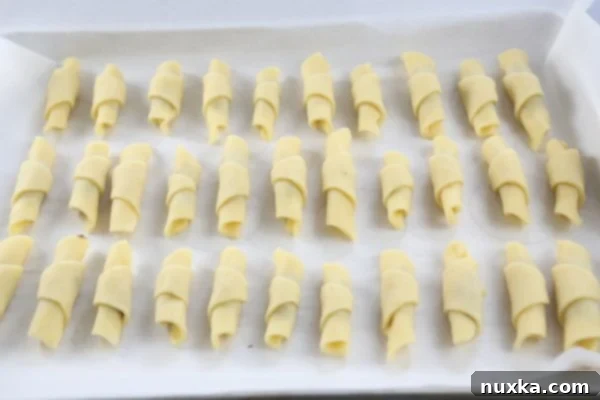 Nutella Rogaliki arranged on parchment-lined baking sheet, chilled and ready for the oven