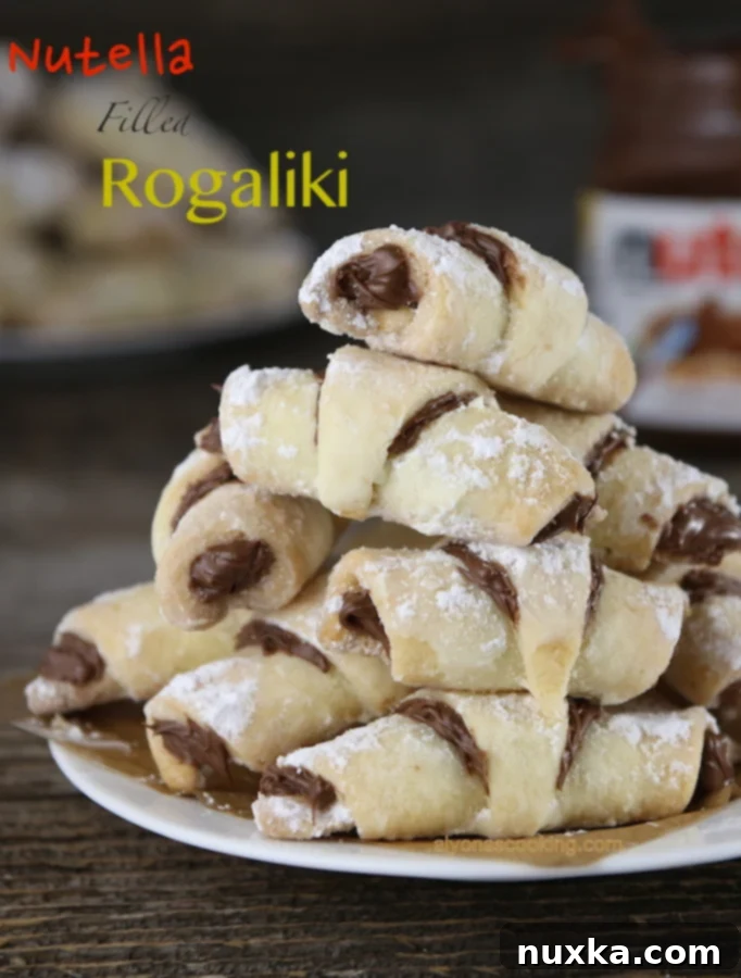 Finished Nutella Rogaliki (Rugelach) cookies, perfectly golden and dusted with powdered sugar