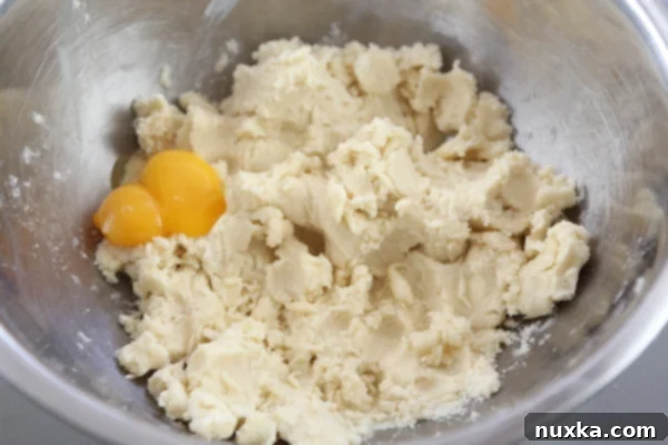 Mixing egg yolks into Rogaliki dough by hand