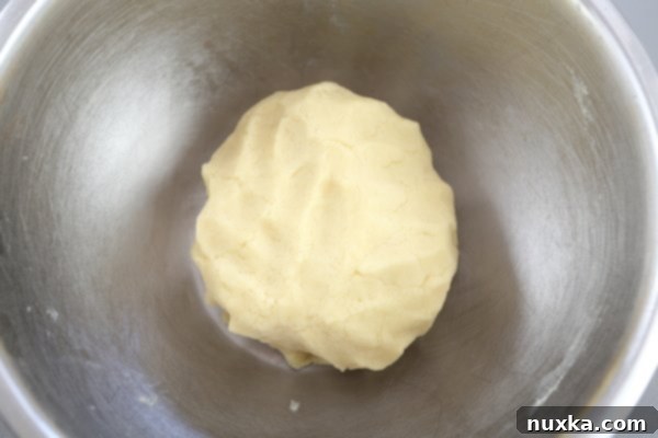 Rolling out one ball of Rogaliki dough into an 8-inch circle