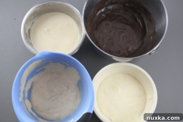 Four bowls of flavored cake batter ready for baking