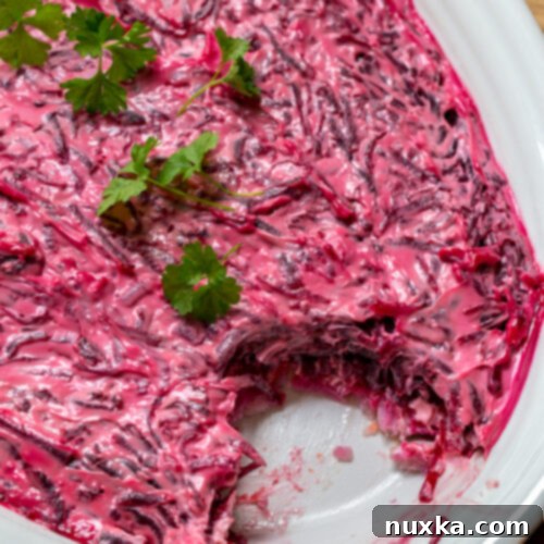 Shuba Salad Made Easy 4 Shuba Salad with herring fish, cooked potatoes, carrots, beets and mayo on an oval serving dish