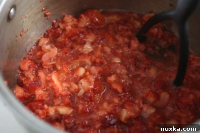 mashed strawberries with sugar and lemon juice in a pot
