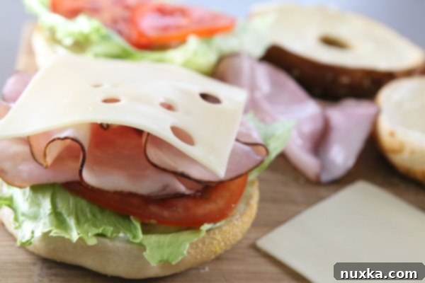 Layering ingredients on Asiago Bagel